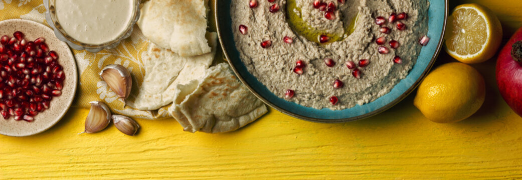 Baba ganoush or mutabal, Middle Eastern eggplant dip sauce garnished with pomegranate seeds, with various ingredients