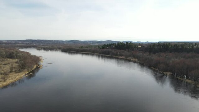A beautiful aerial 4K shot of the Chippewa River in Durand, Wisconsin surrounded by a leafless forest
