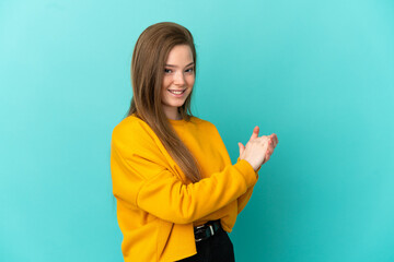 Teenager girl over isolated blue background applauding