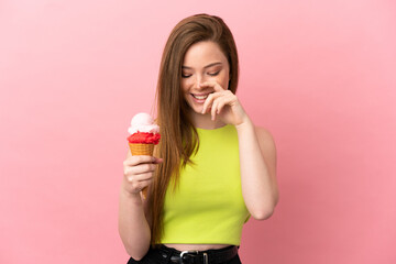 Teenager girl with a cornet ice cream over isolated pink background laughing