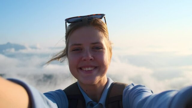 Excited girl backpacker in the mountains, selfie video