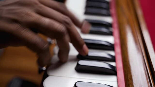A closeup of a hand playing harmonium very quickly in 4K