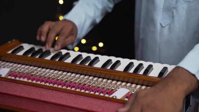 A closeup of hands playing harmonium very quickly in 4K