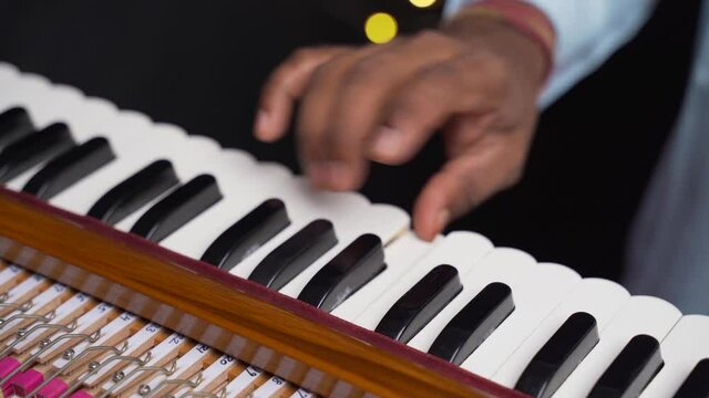 A closeup of a hand playing harmonium very quickly in 4K