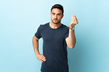 Fototapeta premium Young handsome man over isolated background making Italian gesture