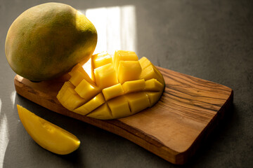 ripe mango cut into cubes on a dark gray background
