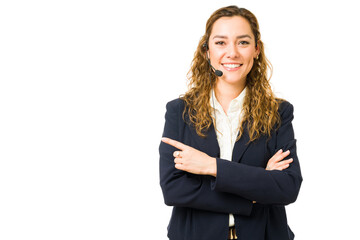Portrait of a woman with a headset pointing to copy space