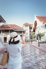 Tourist Woman Having Fun While Sightseeing in The Temple, Rear View of Asian Tourist Woman Relaxing and Enjoy While Photographing Architecture on Her Mobile Phone.