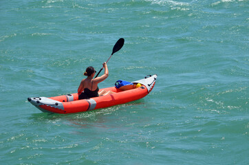 Woman paddling an inflatable canoe