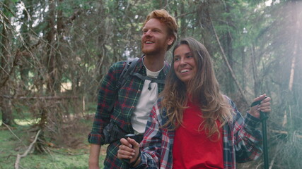 Couple walking in summer woods. Happy man and woman hiking in fairytale forest