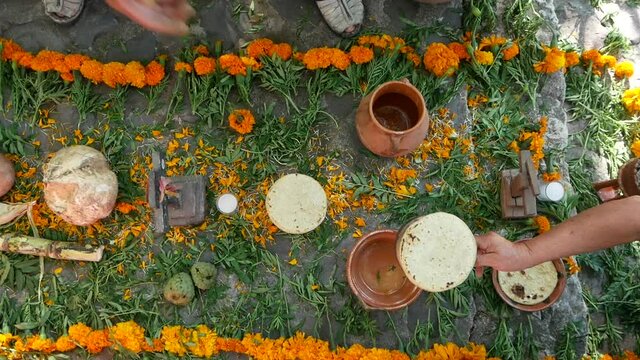 Mexican offering for the day of the dead, people setting up the altar with flower and food for the celebration. 