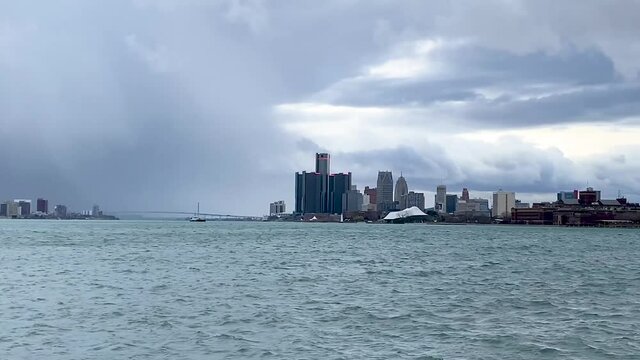 Zoom in shot of Detroit river water on a cloudy day. ambassador bridge is seen in the distance.