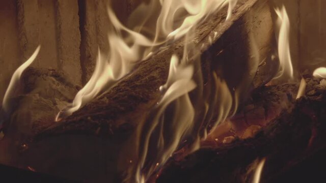 Logs burning on the fireplace in slow motion, relaxing footage to meditate.
