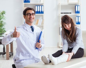 Fototapeta premium Doctor examining patient with broken leg