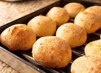 Pão de queijo., comida brasileira. Vários pães de queijo em uma assadeira enfileirados....