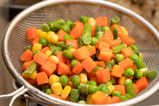Seleta de legumes cozida em peneira met&aacute;lica. Uma mistura de legumes com cenoura, milho, ervilha e vagem. Comida, refei&ccedil;&atilde;o, legumes, vegetais, vegetariana.