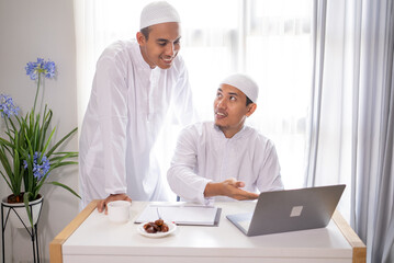 two muslim business partner discussing and meeting using laptop together