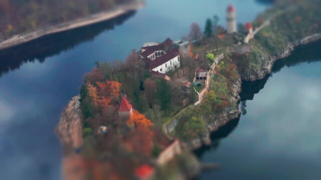 Aerial view of the Hrad Zvikov - a beautiful medieval castle standing on the peninsula on one of the turns of the Vltava river. Overlooking the wide river and the forest. A tilt-shift video.