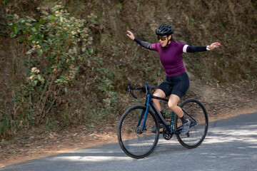 Fototapeta na wymiar Mujer joven disfrutando de un paseo en bicicleta al aire libre en medio del bosque.