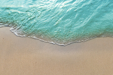 Summer with turquoise wave in tropical beach. Soft waves with foam of blue ocean on the sandy beach.