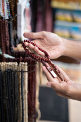 close up hand of asian muslim man shopping for islamic beads