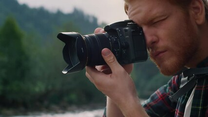 Man taking photos on photo camera. Male tourist adjusting zoom on camera lens