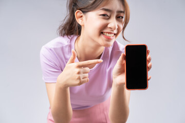 Young Asian woman showing smartphone's blank screen