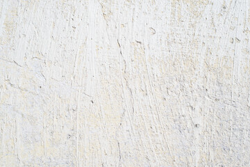 Textured light background with peeling white paint. Cracked surface