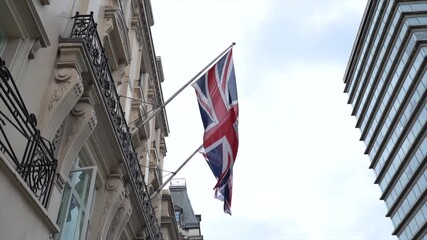 A low angle shot of UK flag waving embassy in London, England in 4K