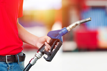 Hand of worker holding fuel nozzle at the gas station. Gas pump service and refuelling car at the station oil