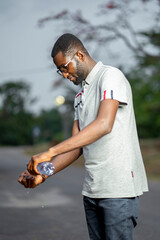 selective focus of african guy with bottle of water, hand wash out door concept