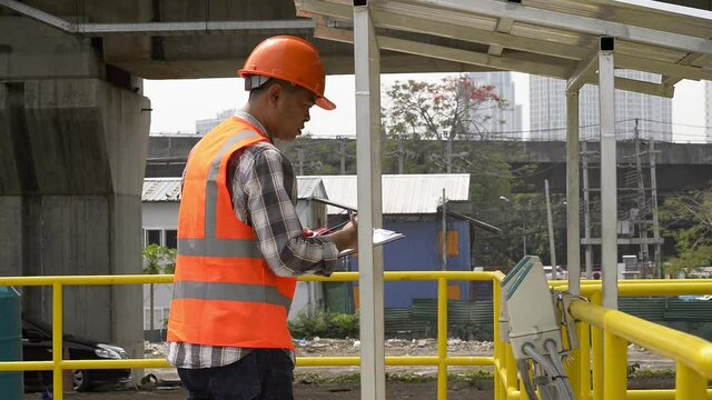 worker on a site. worker checking flow meter and test on water plant.  service engineer checking  flow meter on plant.