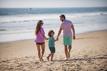 Happy young family on summer beach. Family leisure activities concept.