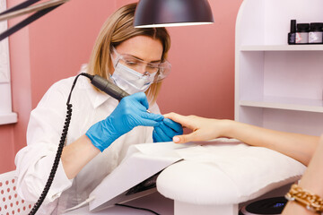 Woman on manicure treatment in beauty salon. Manicure, beauty procedures and personal care. Portrait