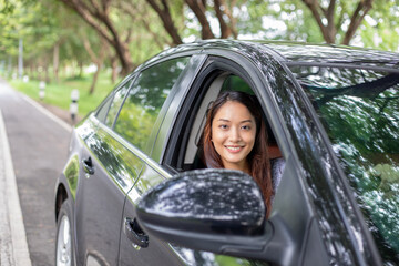 Beautiful Asian woman smiling and enjoying.driving a car on road for travel