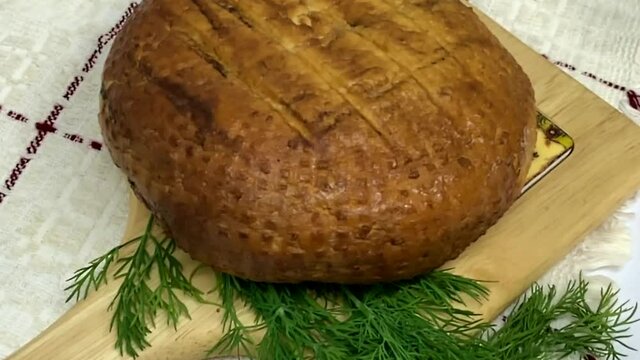 Round soft brown smoked homemade cheese. Adyghe cheese with greens lying on wooden board . HD