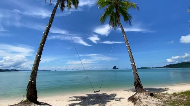 Swing between two palm trees in paradise white sand beach in koh yao yai island, phuket province, Thailand
