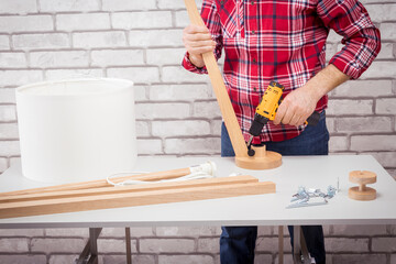 Man electrician  assemble floor lamp for home decoration. Concept DIY.