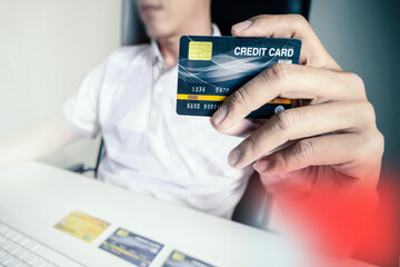Man paying with credit cards on computer at home.
