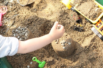 自宅の砂場で遊ぶ子供 - obrazy, fototapety, plakaty