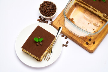 Traditional Italian Tiramisu dessert in glass baking dish and portion on plate on white background