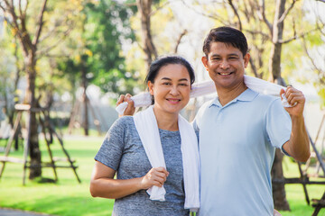 Couple older Asian men and women wear exercise clothes before their morning exercises.poritrait Old men and women use towels to wipe their sweat after jogging in the garden