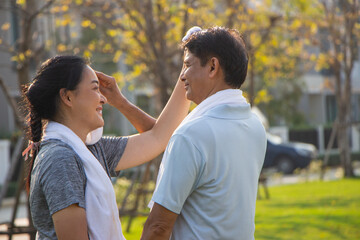 Couple older Asian men and women wear exercise clothes before their morning exercises.poritrait Old men and women use towels to wipe their sweat after jogging in the garden
