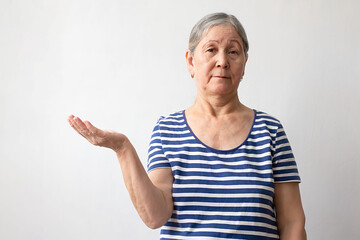 Elderly woman, gray-haired lady of the 60s in a striped white and blue dress with open arms as friendly welcome, positive greetings on a white background.