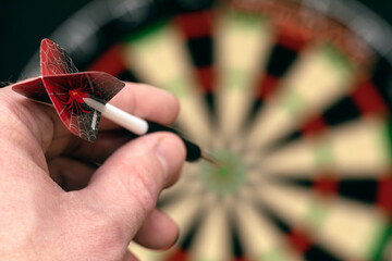 Man hand is holding dart and aiming at target. Achieving goal. game of darts. Aspiration,...