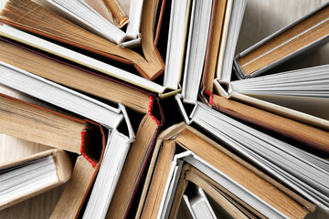 Stack of books on light wooden background, closeup
