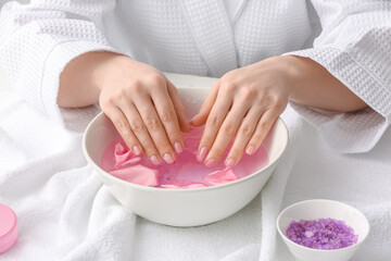 Young woman undergoing spa manicure treatment in beauty salon