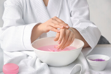 Young woman undergoing spa manicure treatment in beauty salon
