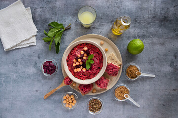 Close-up of a red beet hummus dish with surrounding ingredients