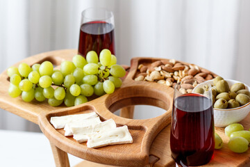 Serving wooden table for wine, glasses and snacks. Handmade segmented Portion wooden table. Grapes, cheese, wine and nuts.  